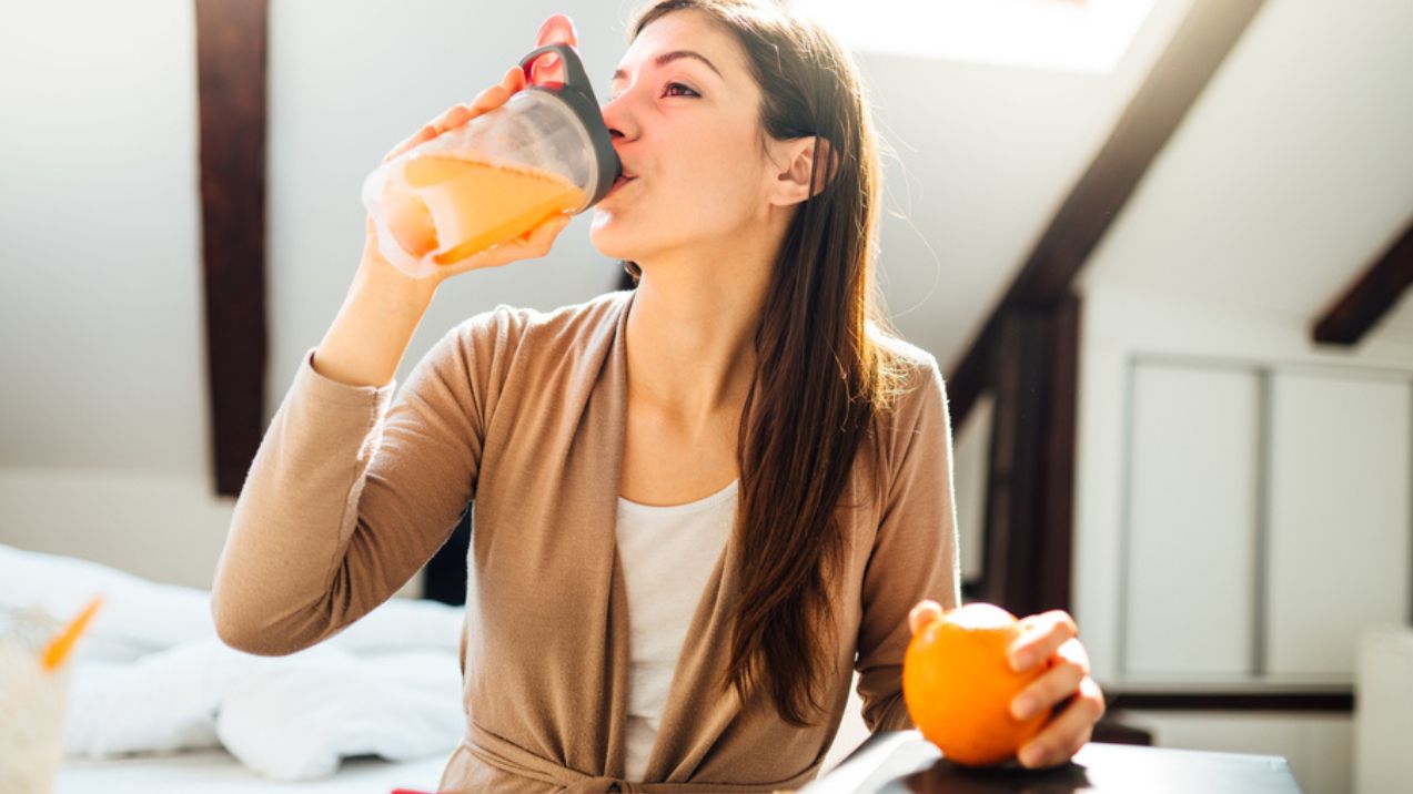 Una ragazza che beve un concentrato di frutta.